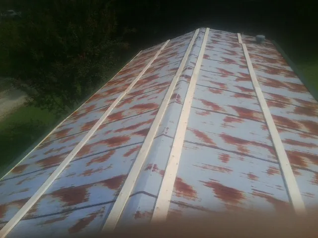Rusted metal roof panels with new wood purlins before replacement — Storm Damage Roof Repair in Cocoa by Roofing Brothers